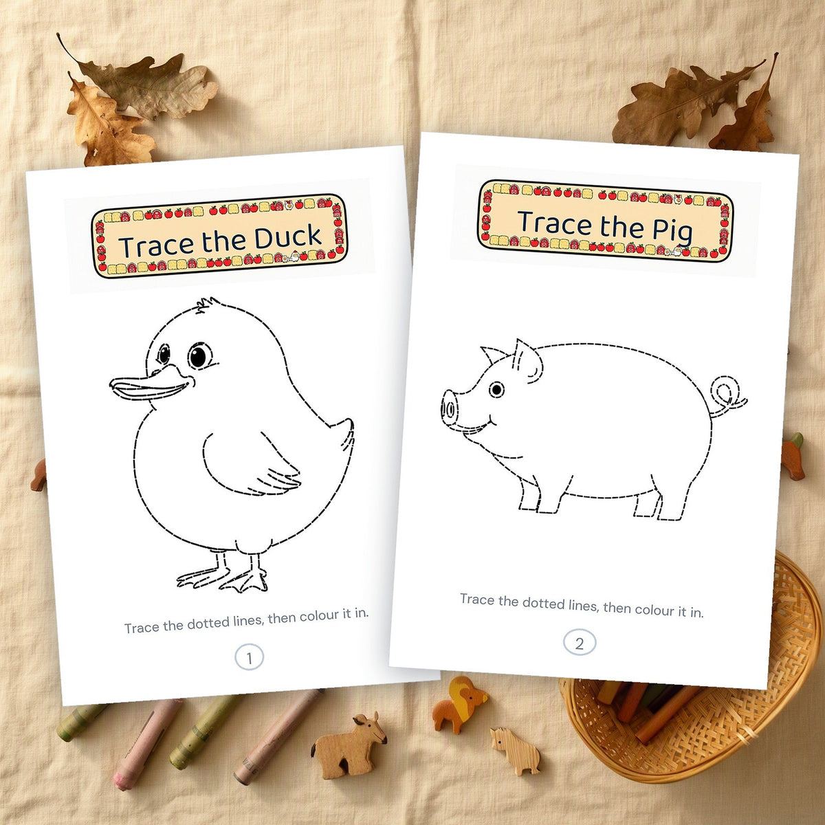 Two printed tracing pages, a duck and a pig in dashed outline, on a linen cloth