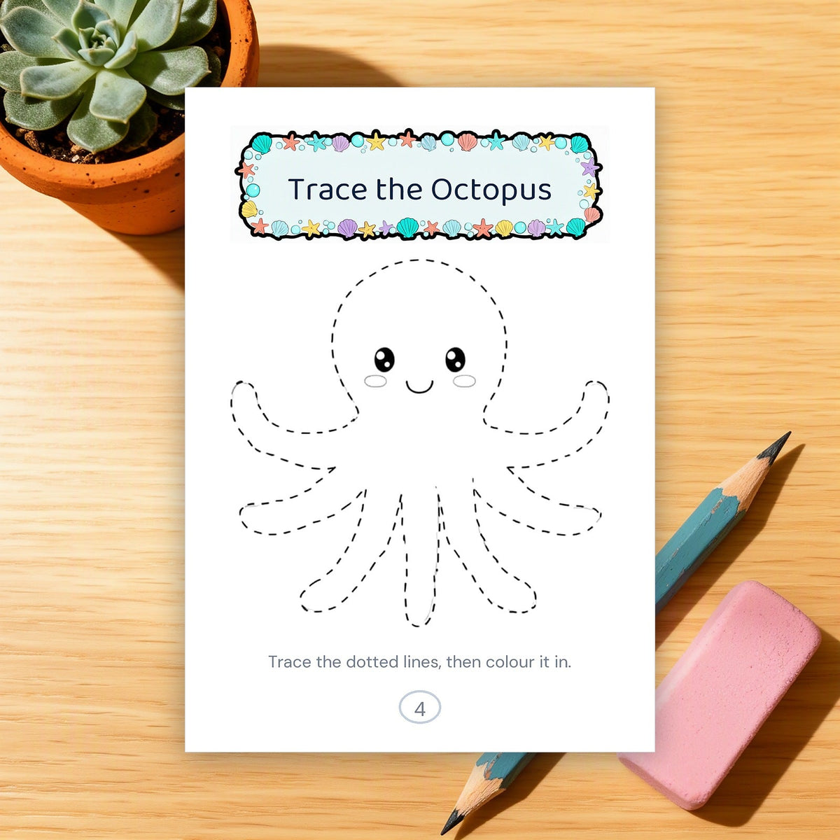 A printed octopus tracing page on a wooden desk with a pencil and an eraser